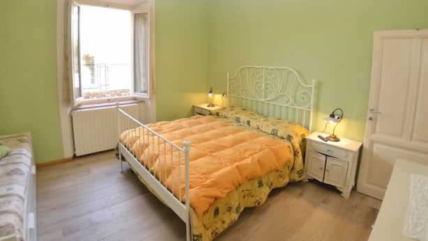 Une chambre à coucher avec un lit, des tables de chevet, une fenêtre et une porte.