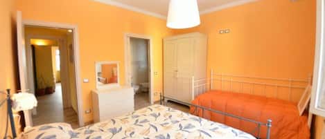 Un dormitorio con cama, cómoda, armario y espejo.