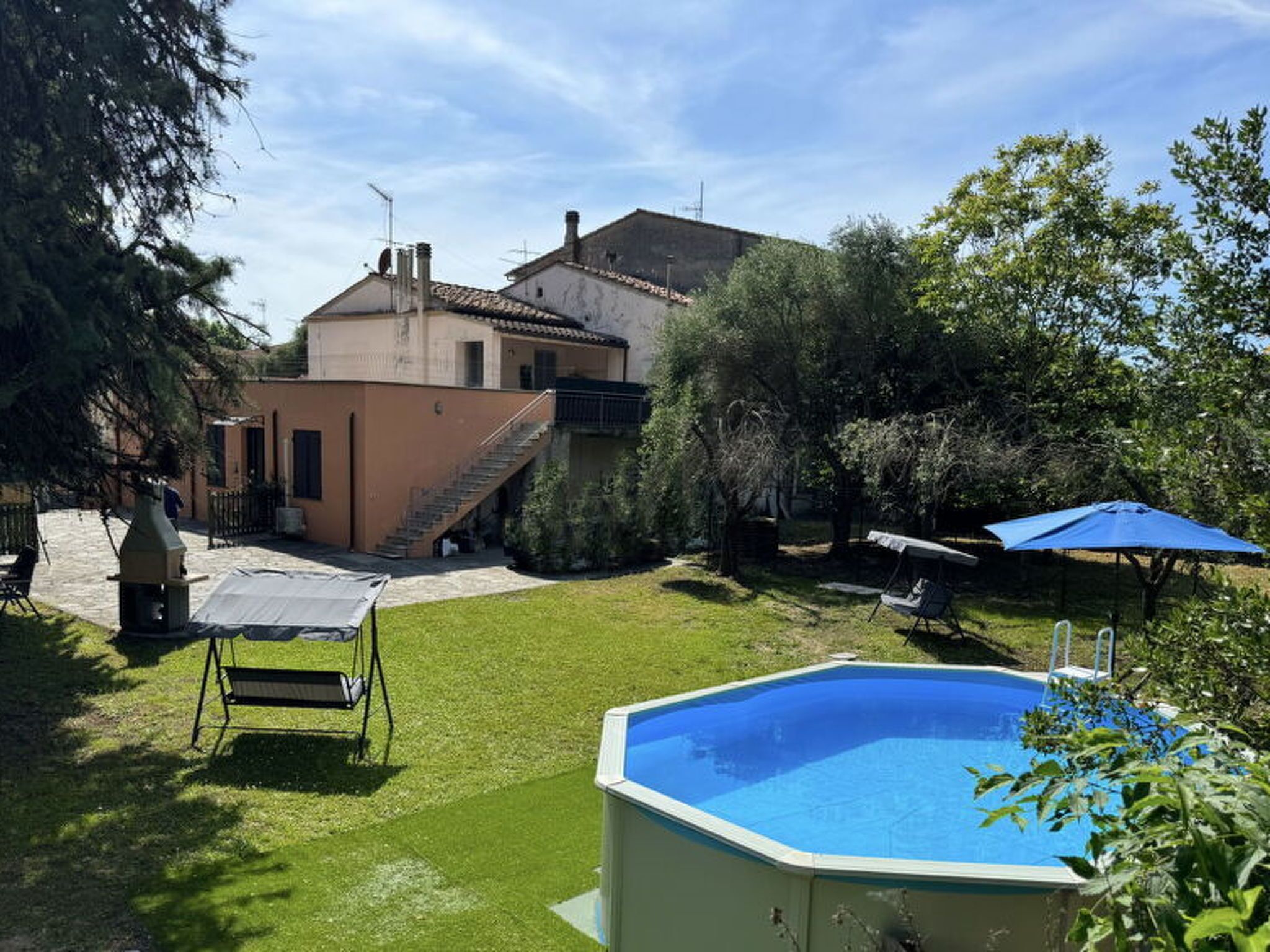 Il s’agit d’une propriété résidentielle dotée d’une piscine, d’un patio couvert et d’un escalier menant à un bâtiment.