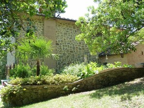 Un bâtiment en pierre, doté d’un mur en pierre et d’un pont en pierre à arc.