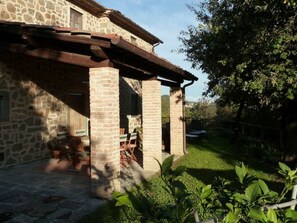 A stone building with a covered patio area, outdoor seating, and a grassy yard. - Le Case Di Carla Zizzola by Interhome (Borgo a Buggiano)