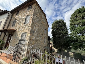 A stone building with a balcony, a metal gate, and a tree in the background. - Casa Max by Interhome (Capannori)