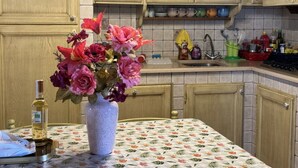 A kitchen with wooden cabinets, a sink, and a vase with flowers on the counter. - Casa Max by Interhome (Capannori)