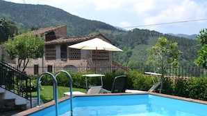 A swimming pool with steps leading into it, surrounded by a fence, with a building and trees in the background. - Casa Max by Interhome (Capannori)