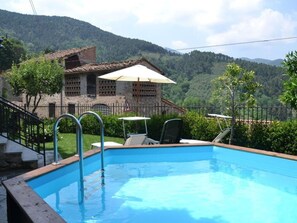 A swimming pool with steps leading into it, surrounded by a fence, with a building and trees in the background. - Casa Max by Interhome (Capannori)