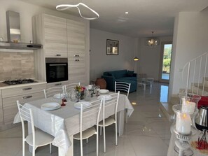 A modern kitchen with a dining area, a sofa, and a staircase. - Villa al Glicine by Interhome (Altopascio)