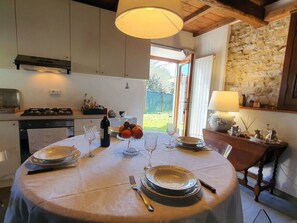 Comedor con una mesa redonda para cuatro, estufa y vista al exterior.