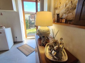 Una habitación con una lámpara, una bandeja con teteras, un refrigerador pequeño y vistas al exterior.