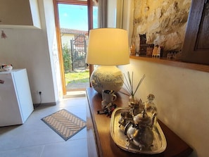 Ein Zimmer mit einer Lampe, einem Tablett mit Teekannen, einem kleinen Kühlschrank und Blick nach draußen.
