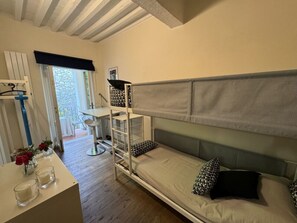 Ein Zimmer mit einem Etagenbett, einem Schreibtisch und einem Stuhl.