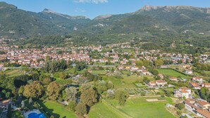 Una cittadina situata in una valle, con montagne sullo sfondo, caratterizzata da edifici residenziali e aree verdi.