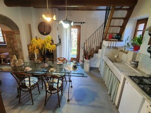 A dining area with a glass table, chairs, and a vase of yellow flowers. - Il Cantuccio by Interhome (Colognora)