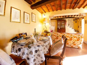 A dining area with a table set for two, a chandelier, and a staircase leading to a second floor. - La Casa Del Sole by Interhome (Capannori)