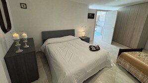 A bedroom with a bed, bedside tables, a nightstand, a dresser, and a view of the outside. - Villa al Glicine Proprietà by Interhome (Altopascio)