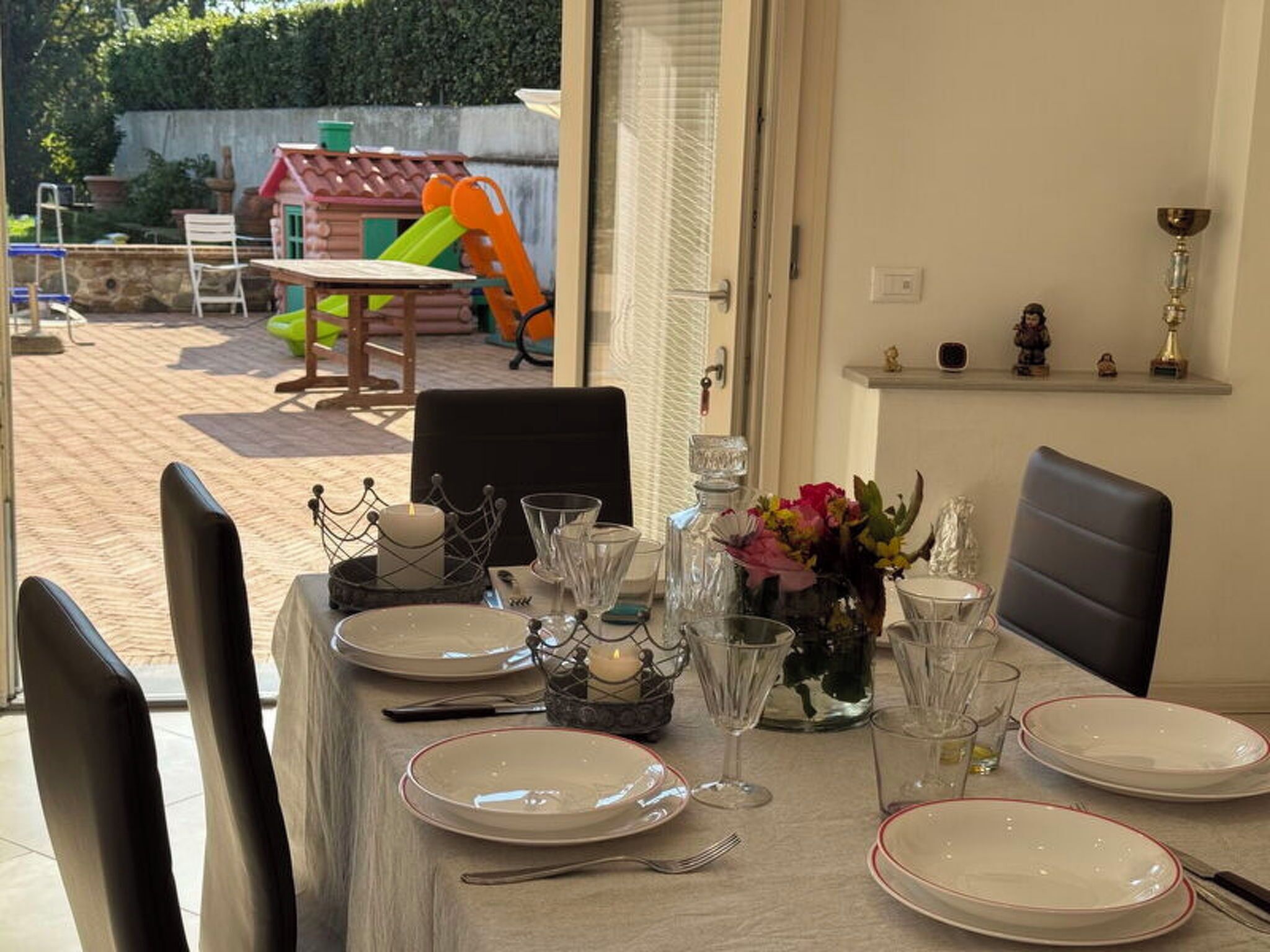 A dining table set with plates, glasses, and a candle centerpiece.