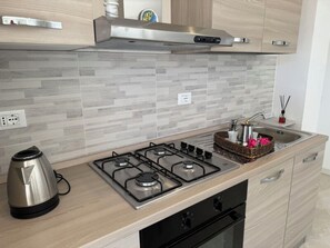 A modern kitchen with a gas stove, a kettle, and a sink. - Villa al Glicine Proprietà by Interhome (Altopascio)