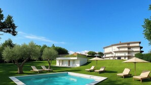 A pool with lounge chairs, a white building, and a larger multi-story building in the background. - Villa al Glicine Proprietà by Interhome (Altopascio)