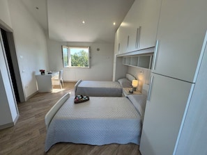A modern hotel room with two beds, a desk, a chair, and a window. - Villa al Glicine Proprietà by Interhome (Altopascio)