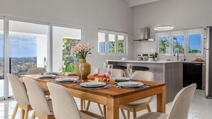 Une cuisine moderne avec un coin repas, de grandes fenêtres et une vue sur la ville.
