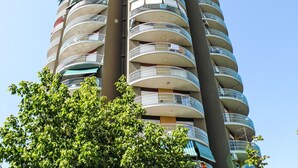 Un edificio de gran altura con varios balcones, algunos con barandillas y otros sin ellas.