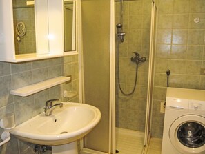 A bathroom with a sink, mirror, shower, and washing machine. - Villa Maria 2 by Interhome (Lignano Pineta)