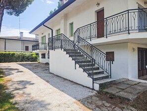 Ein zweistöckiges Gebäude mit einer Treppe und einem Balkon.