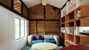 Een kamer met een bank, een ronde tafel en houten planken met speakers.