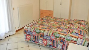 Un dormitorio con cama, armario y radiador.