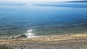 Ein Strand mit klarem Wasser und Kiesküste.