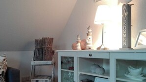 A room with a white cabinet containing glassware, a framed picture, and a sign that reads 'WILKOMEN'. - Wat(t) ne Wohnung by Interhome (Büsum)