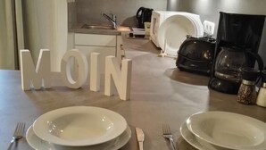 Uma mesa de jantar com pratos, talheres e a palavra 'MOIN' em letras grandes.