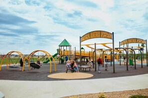 Un parque infantil con columpios, toboganes y estructuras para escalar.
