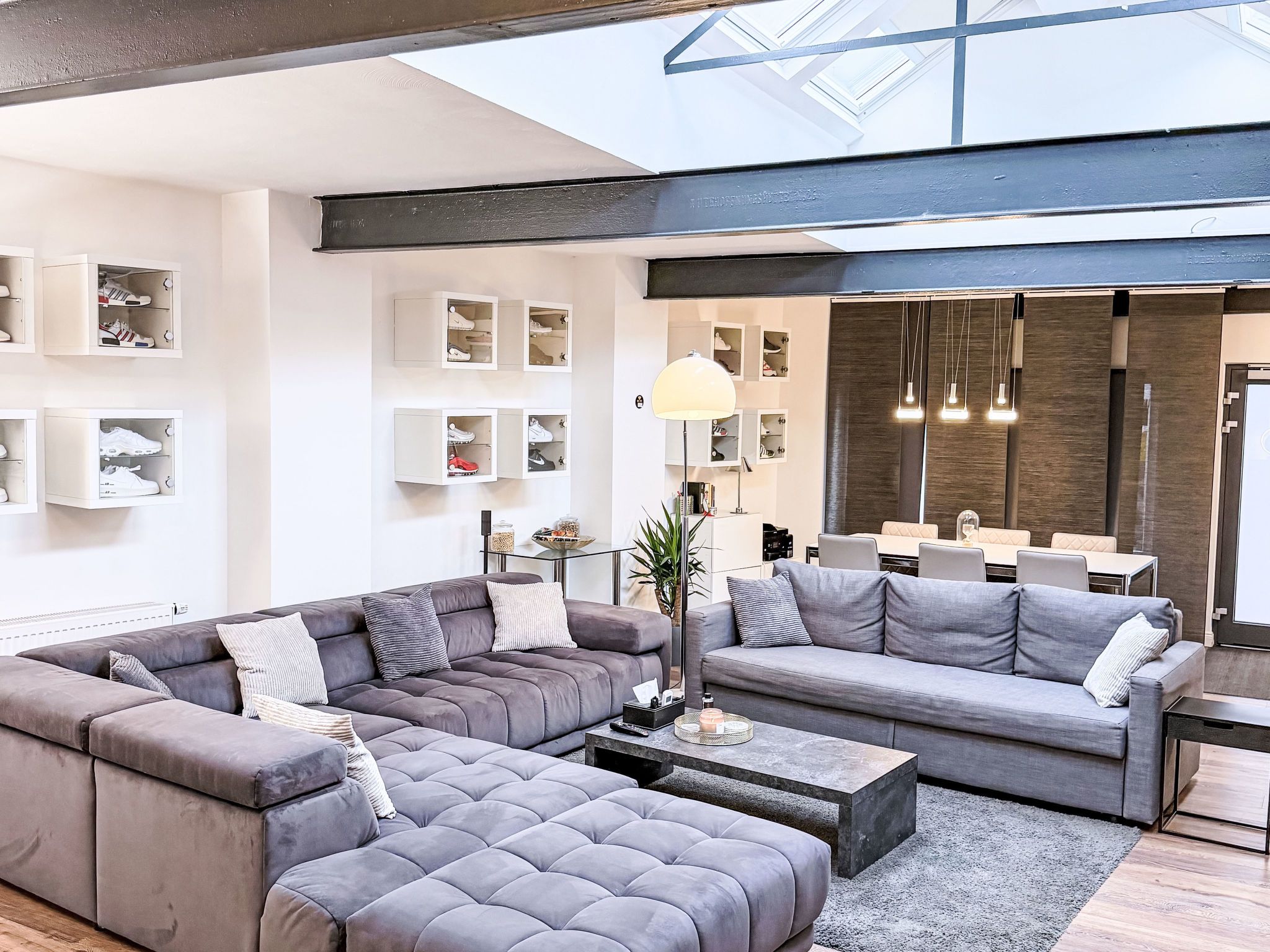 Ein modernes Wohnzimmer mit einer Eckcouch, einem Couchtisch und integriertem Schuhschrank.