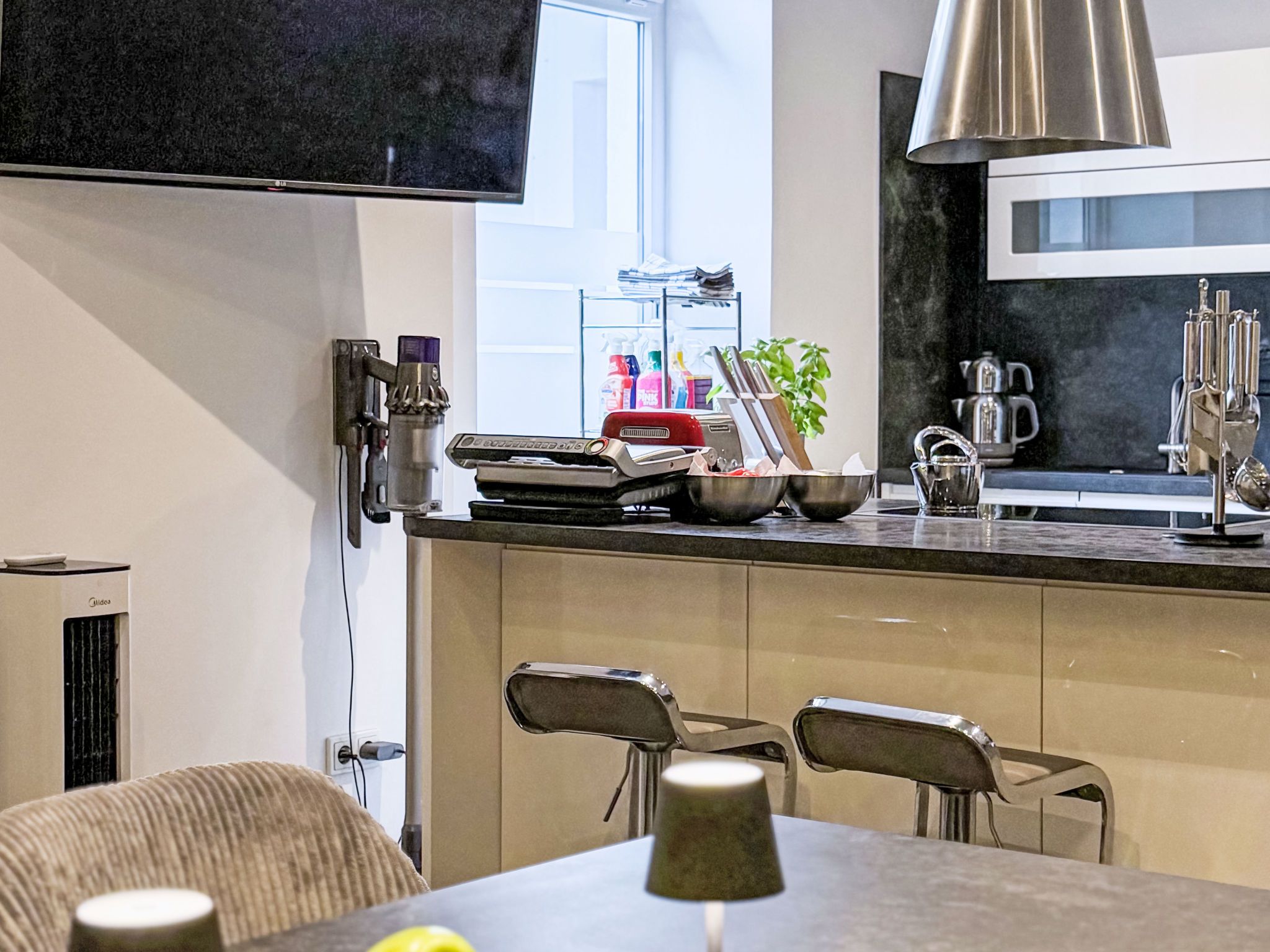 Una cocina moderna con una isla integrada, electrodomésticos de acero inoxidable y una zona de comedor con sillas.