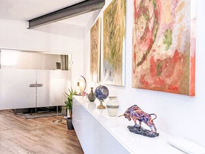 Un intérieur moderne avec un comptoir d’accueil blanc, des tableaux abstraits et un globe terrestre.