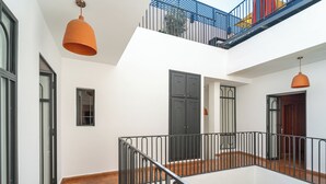 Et flerniveaumiljø med balkon, trappe og dør.