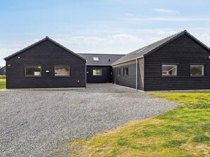 A modern black building with a gravel driveway and a grassy area. - 18 Person Holiday Home in Romo (Rømø)