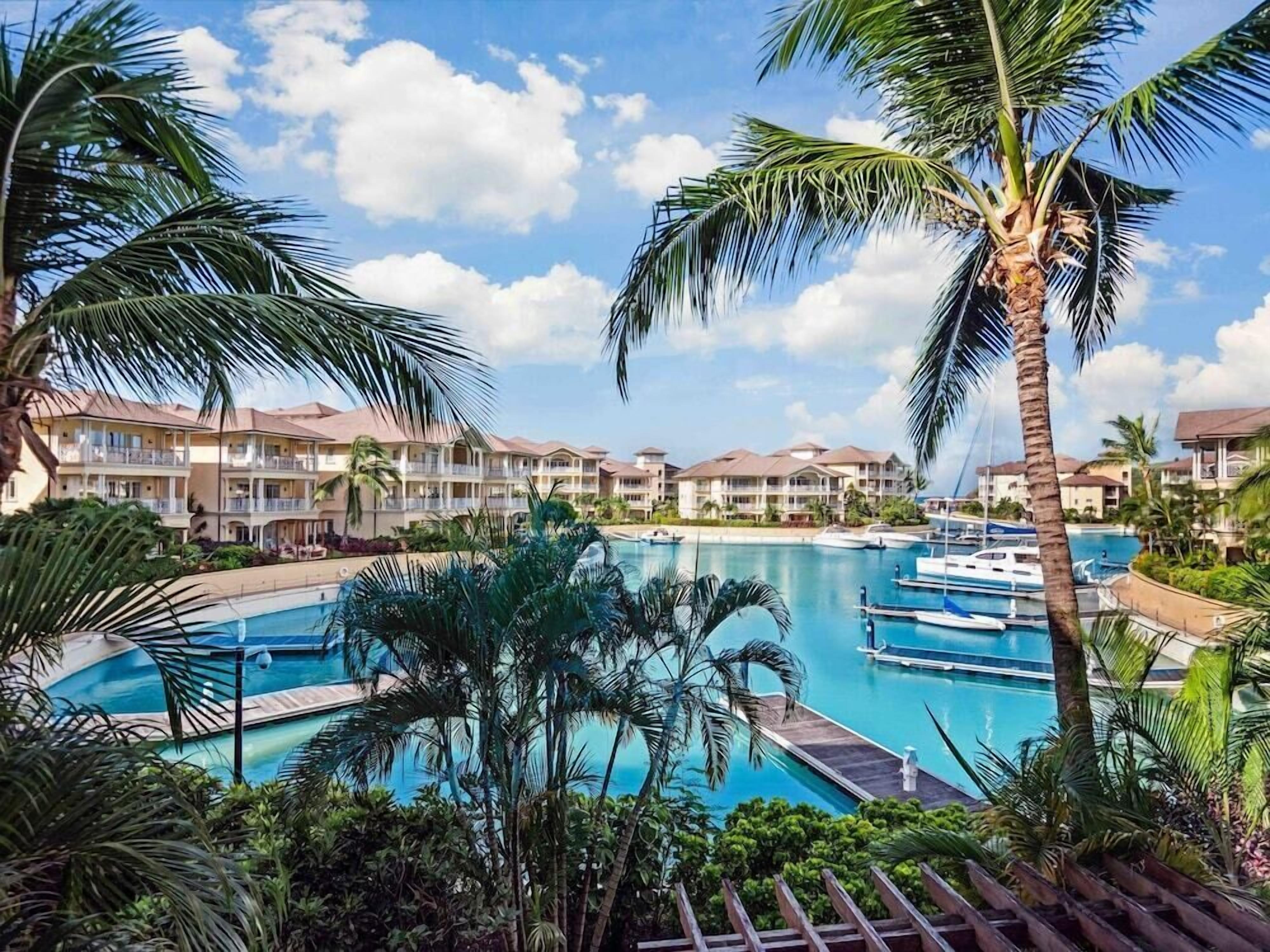 Ein Resort mit mehreren Schwimmbecken, Palmen und Blick auf Hotelgebäude.