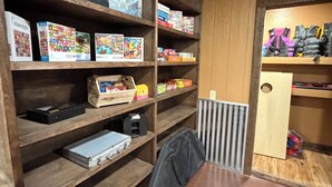 Ein Zimmer mit Holzbögen, gefüllt mit verschiedenen Gesellschaftsspielen und Puzzles.