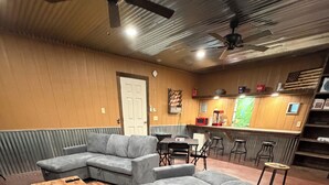 Ein gemütlicher Wohnbereich mit einem Ecksofa, einem Couchtisch und einem gemusterten Teppich.