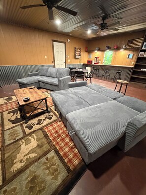 A cozy living area with a sectional sofa, a coffee table, and a patterned rug. - Your lakefront retreat with private boat slip, firepit, game room & wildlife ❤️ (Canadian)