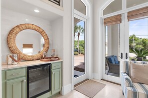 A kitchen with a large woven mirror, a built-in oven, and a view of the outdoor patio. - Blue Mountain Bella | Pool + Golf Cart + Steps to Beach (Santa Rosa Beach)