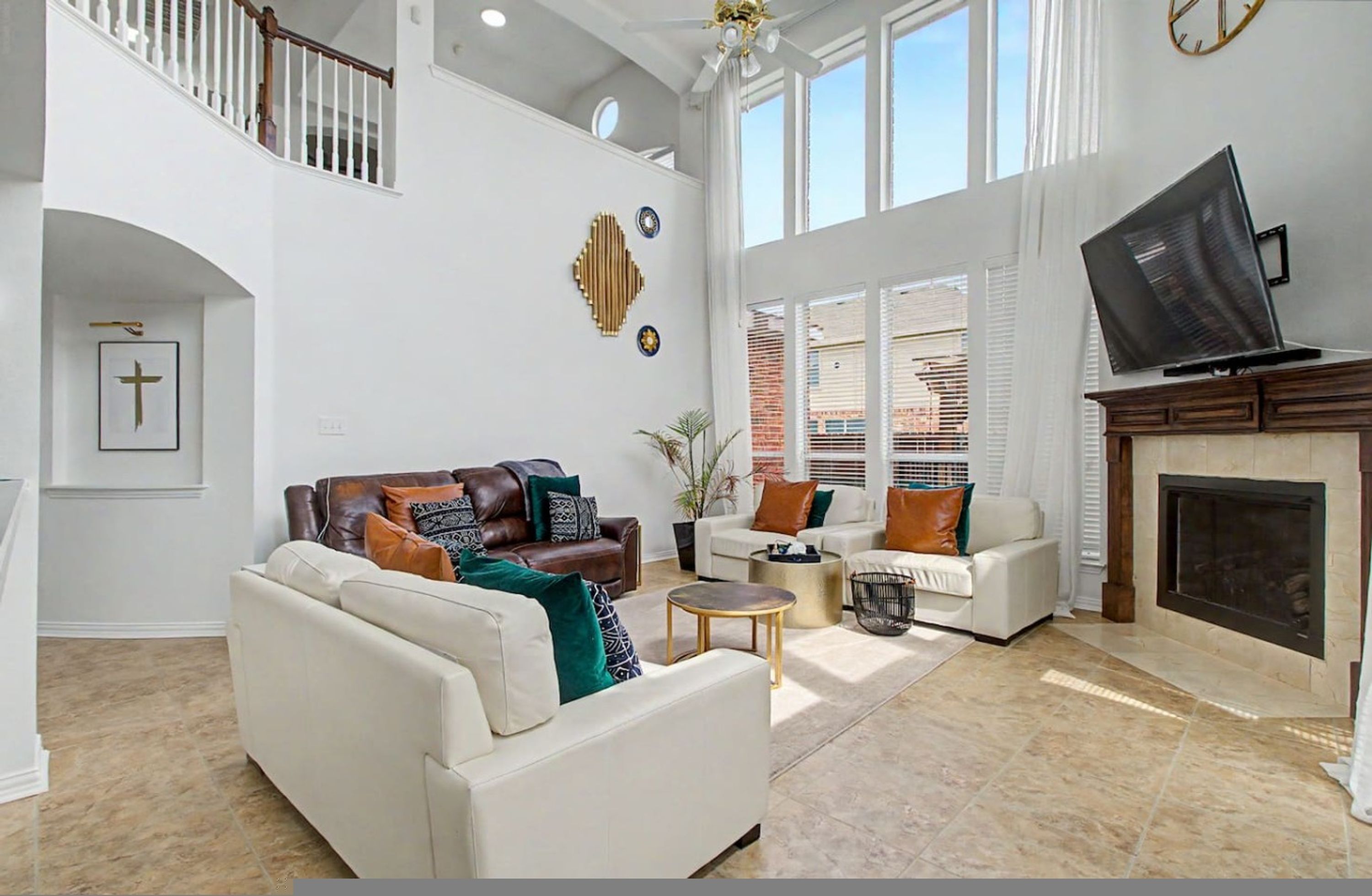 Un salón amplio con chimenea, televisor y escalera.
