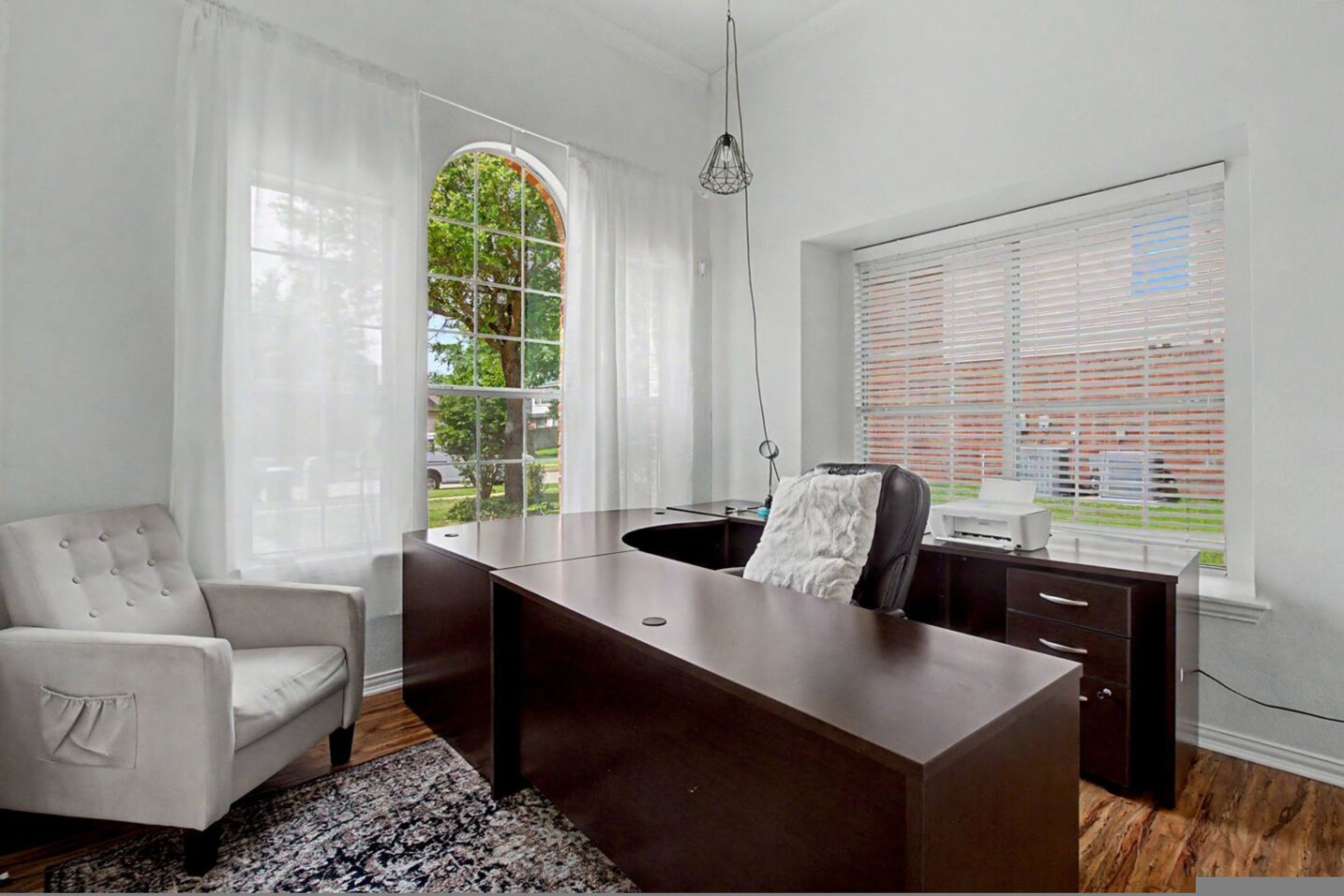A modern office with a desk, chair, and large windows.