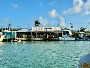 Ein Restaurant mit Wasserrandlage namens 'Dockside', mit Außenbereich, einem Steg und Booten sowie einer Flagge.