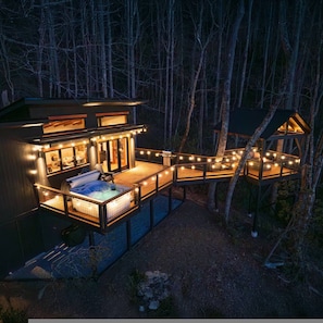 A cabin with a hot tub, deck, and string lights. - Outdoor Movies w Hot Tub Fire Pit Mtn Views (Penrose)