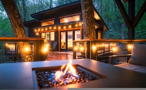 A modern cabin with a deck, a fire pit, and a glass door entrance. - Outdoor Movies w Hot Tub Fire Pit Mtn Views (Penrose)
