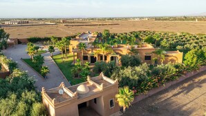 Un resort en el desierto con varias edificaciones, palmeras y una extensa explanada.