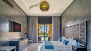 Un dormitorio moderno con cama, mesitas de noche, televisor y vistas al exterior.