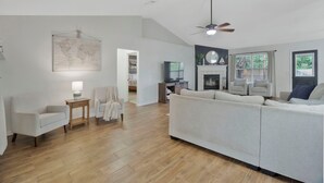 Un salon spacieux avec un grand canapé, une petite table et une carte du monde accrochée au mur.